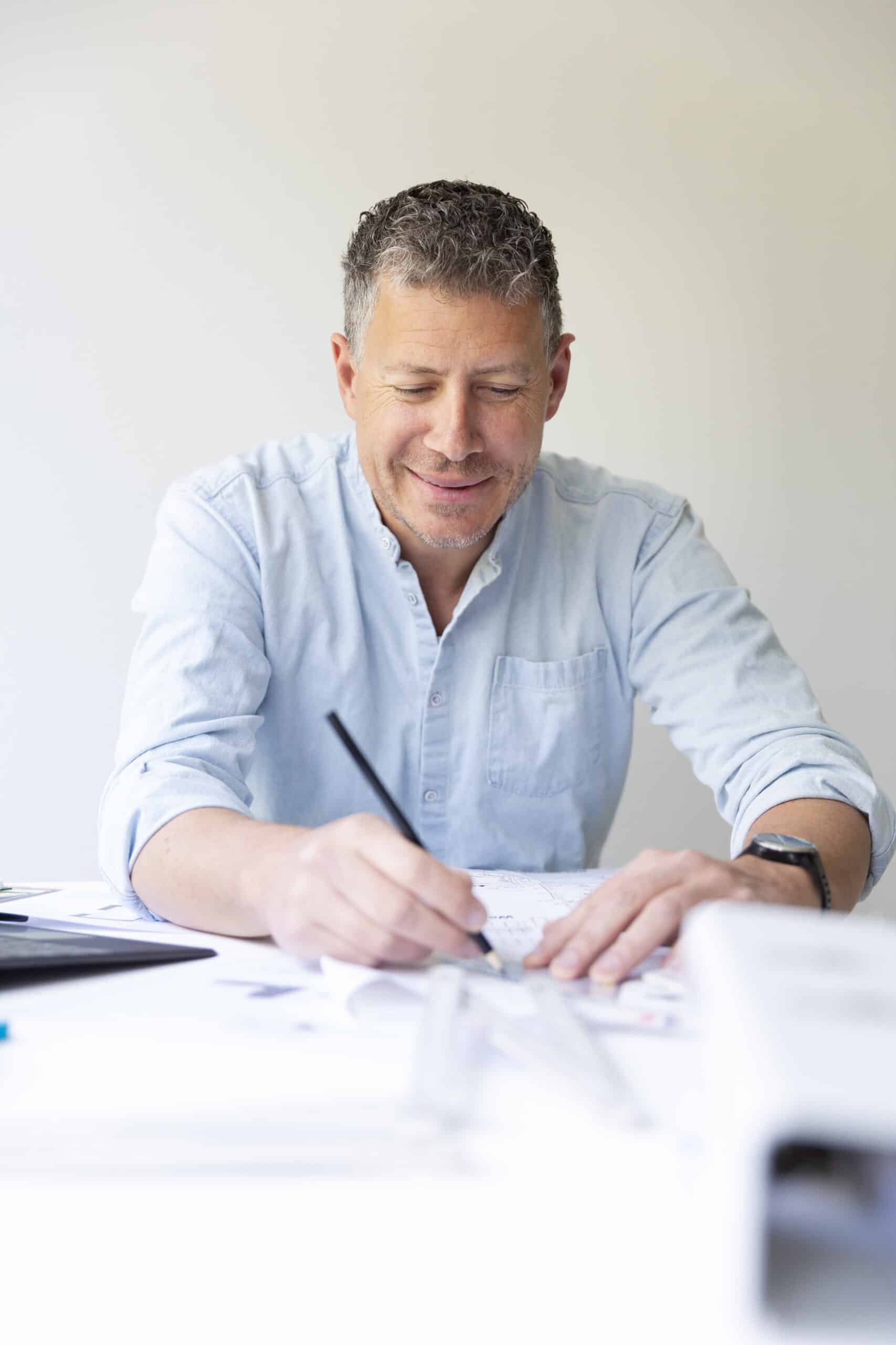 Business portrait of architect sitting at his work table and planning